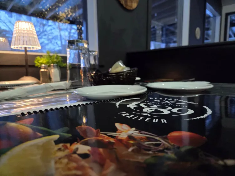 Table dressée au Restaurant Le 1889 avec menu et ambiance tamisée en soirée